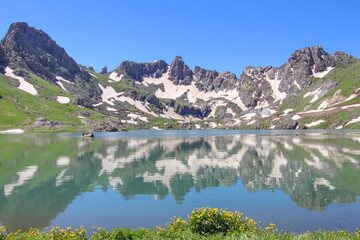 a glacial lake in mountains, winter season, cold weather and blue sky, snowy mountains
