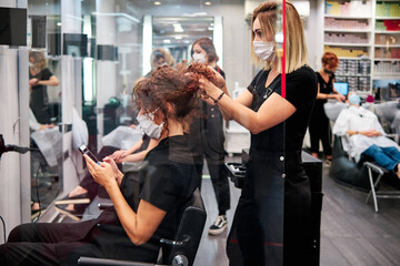 women in a beauty salon with social distance and protective masks