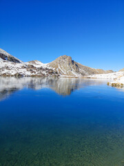 Fototapeta na wymiar a glacial lake in mountains, winter season, cold weather and blue sky, snowy mountains 