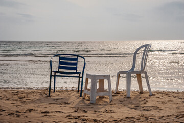 Chairs on the sandy seashore against the sky