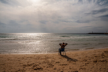 Girl on the sandy seashore against the background of the sun