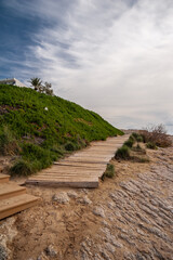 Walkway on the stone seashore against the background of the sea.