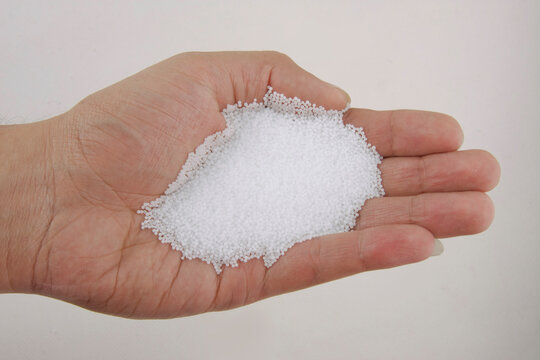 Hand holding white polystyrene foam beads ball drop
