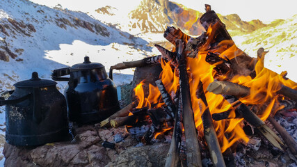 wood fire and lake view in snowy mountains
