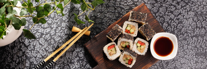 Roll with vegetables and fish paste with a sesame cap. Sushi menu bar. Japanese food Sushi served top view.
