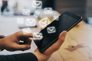 Hands holding tablet with creative email symbol