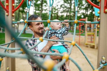 Father with his little son on playground in park