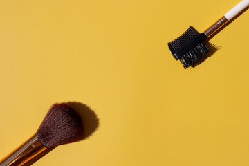 Brush and brow comb on yellow background. Beauty concept. 