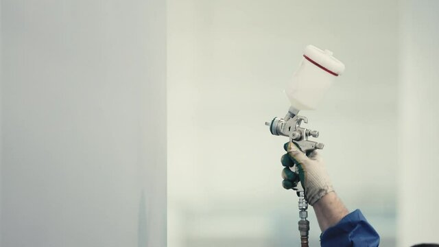 Worker Painting steel construction with Spray Pistol  close up