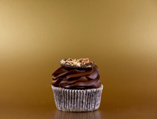 Chocolate cream cupcake on a golden background stock images. One delicious cupcake festive gold frame stock images. Chocolate cupcake golden border with copy space for text
