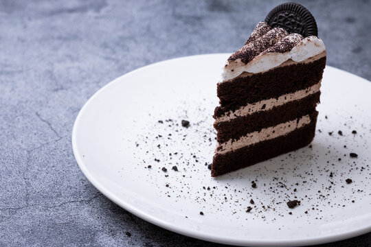 Cookie and Cream Cake is delicious on white plate and gray background.
