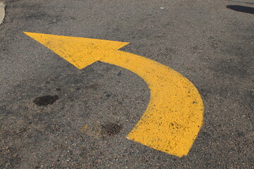 yellow painted parking lot turn arrow to guide automobile drivers