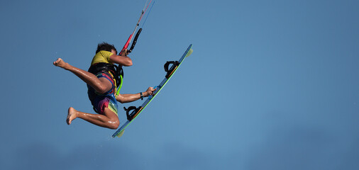 Naklejka na ściany i meble Athletic man jump on kite surf board on a sea waves, kiteboarding action photos