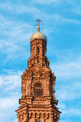 Old brick bell tower of the Orthodox Church against the blue sky