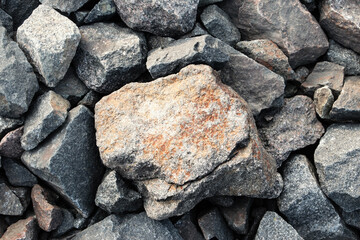 Rocks on the beach. Among the small stones, a large red-tinged stone lies in the center. Beautiful background Wallpaper screensaver