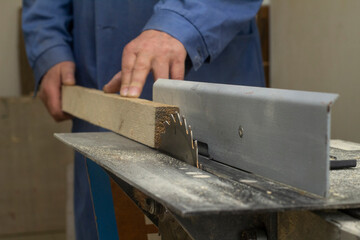 an elderly carpenter handles the bar on the machine. men's work with tools. High quality photo