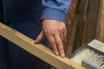 an elderly carpenter handles the bar on the machine. men's work with tools. High quality photo