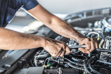 Obraz na płótnie Canvas Auto mechanic working and repair on car engine in mechanics garage. Car service.