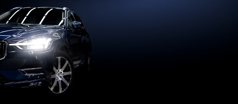 Black modern car on black background. © REDPIXEL