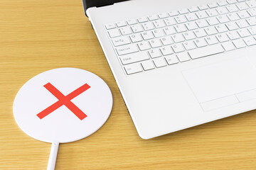 テーブルの上のノートパソコンとマルバツプレート