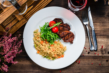 grilled meat and couscous on wood table