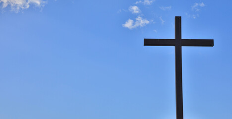 Holzkreuz vor blauem Himmel mit Wolken, Textfreiraum