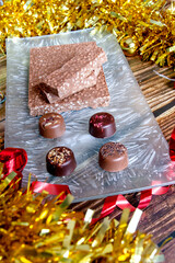 Turron is a typical Christmas food in Spain. This one is made with chocolate and puffed rice. There are also chocolate bonbons with blackberries, hazelnuts and almonds. Lateral upper plane. 