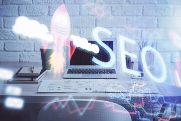 Multi exposure of table with computer and seo drawing hologram. Search optimization concept.