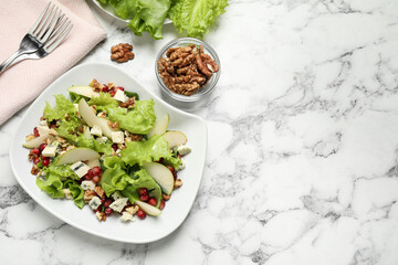 Tasty salad with pear slices and walnuts on white marble table, flat lay. Space for text