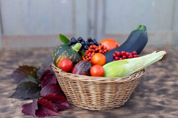 Composition of fresh vegetables in a basket on a wooden background. Autumn harvest. Happy Thanksgiving.