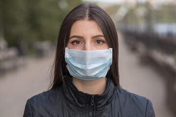 Woman portrait outdoors in a medical mask