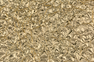 Crumpled gold foil as background, texture, pattern.