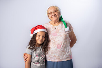 Elderly woman and child with Christmas hat together, gray gradient background, selective focus.