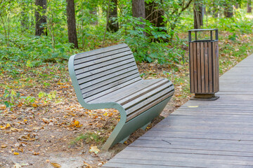 A recreation bench made of boards and wrought iron in a city park in autumn