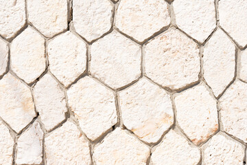 Empty wall made of rocky hexagons in beige tone. Background with copy space, banner