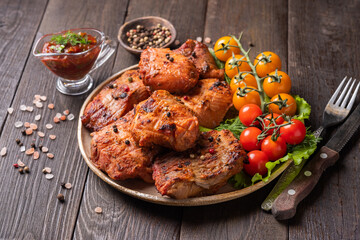 Grilled catfish fish with cherry tomatoes on wooden background