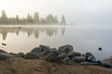 Rocks in fog by a lake shore