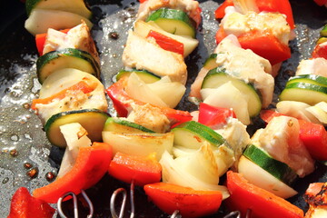 delicious shish kebab skewers in the pan with peppers and onions
