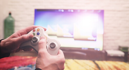 A man is playing a game while lying on the floor. Playing on the console. © alexkich