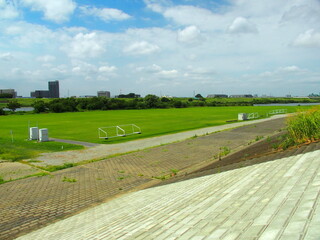 晩夏の江戸川土手から見る護岸と河川敷のグラウンド風景
