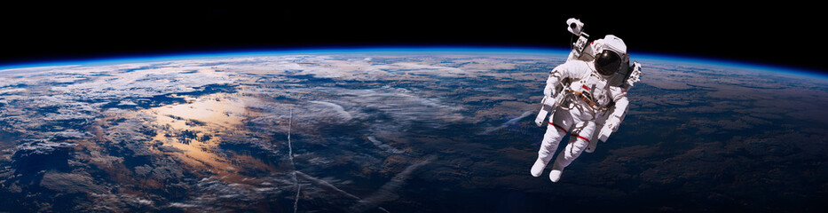 Astronaut walking in space with earth background. Elements of this image furnished by NASA - Powered by Adobe