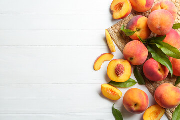 Fresh sweet peaches on white wooden table, flat lay. Space for text