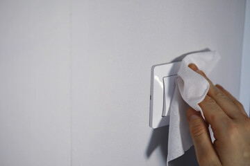 House cleaning concept. Wipe dust off surfaces. Disinfectant treatment of door handles TV...