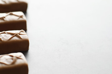 Chocolate bars on a black background in backlight. Chocolate with filling. Sweet sweets for snack and tea.