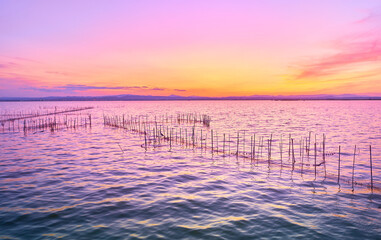 Sunset at the blue sea with a pink reflection from the sky
