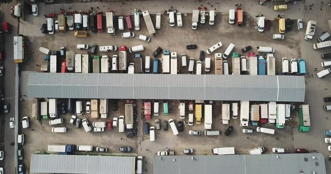 Aerial hyper lapse (hyperlapse - time lapse) of a large logistics park with a warehouse - loading hub. Semi-trucks with freight trailers standing at the ramps for loading/unloading goods