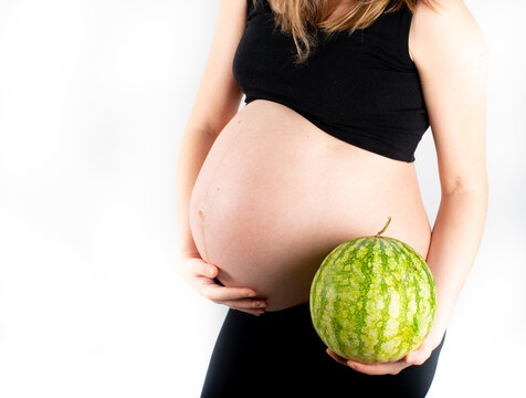 Pregnant woman holding watermelon in her hands. Healthy lifestyle dieting