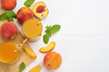 Natural peach juice and fresh fruits on white wooden table, flat lay. Space for text