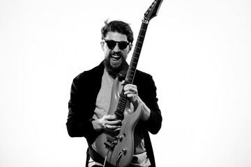 Obraz premium man with guitar in hands musician rock star performance lifestyle light background