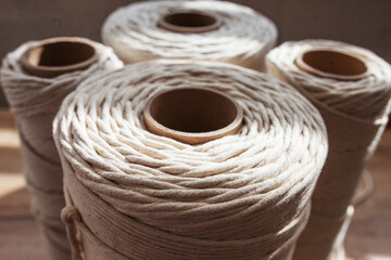 Cotton threads on rustic wooden table. Hobby knitting cotton thread reel on a wooden board. Female hobby macrame